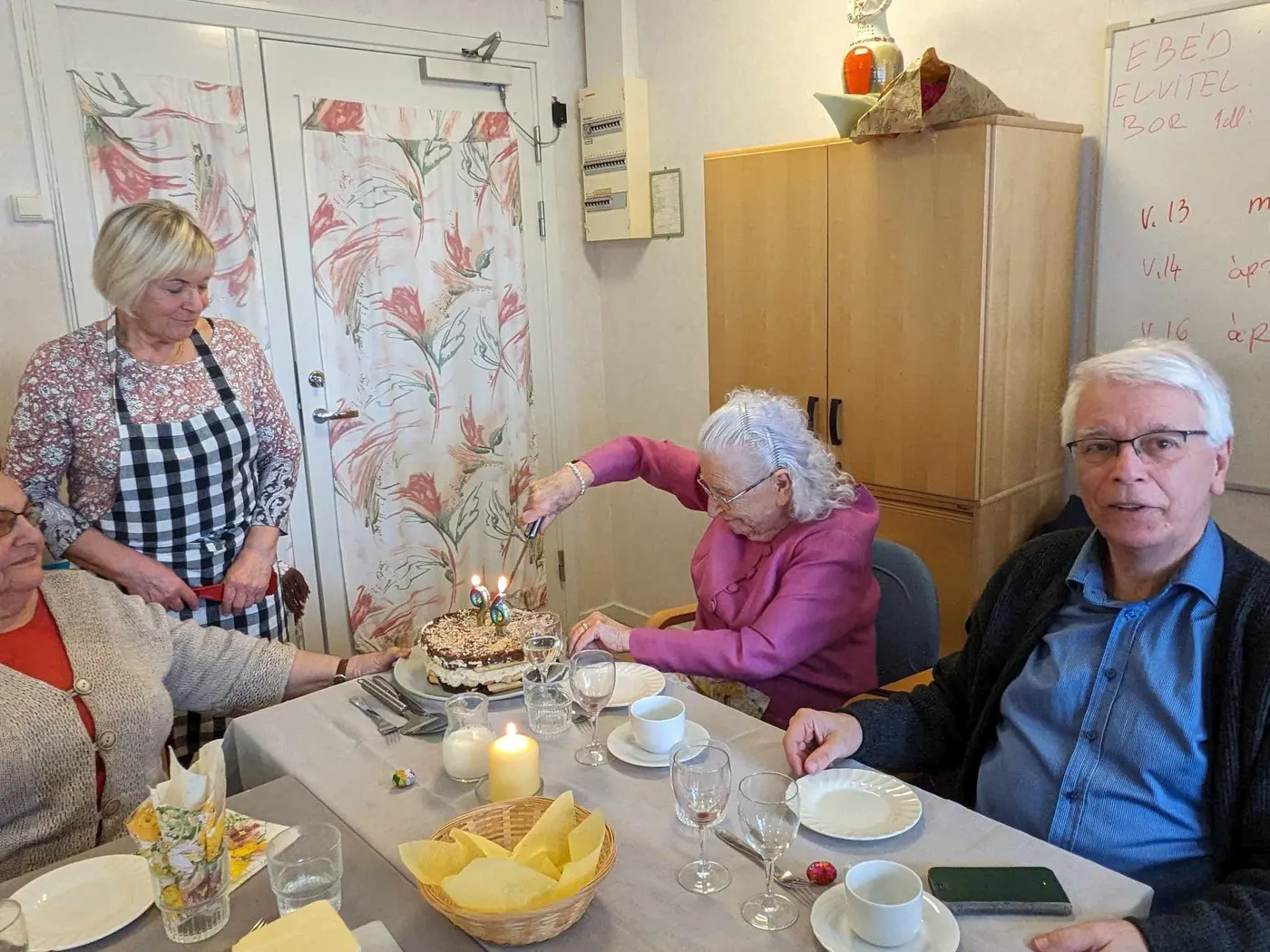 Födelsedagsbarnet skär upp sin tårta med 96 ljus