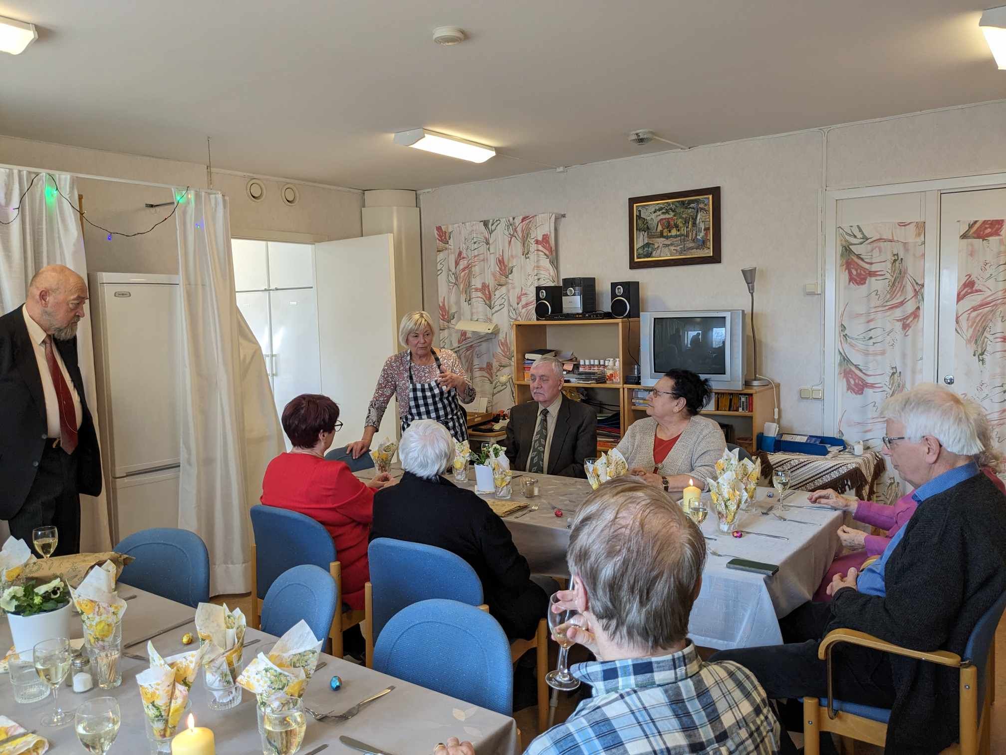 Värdinnan hälsar gästerna välkomna till påsklunchen